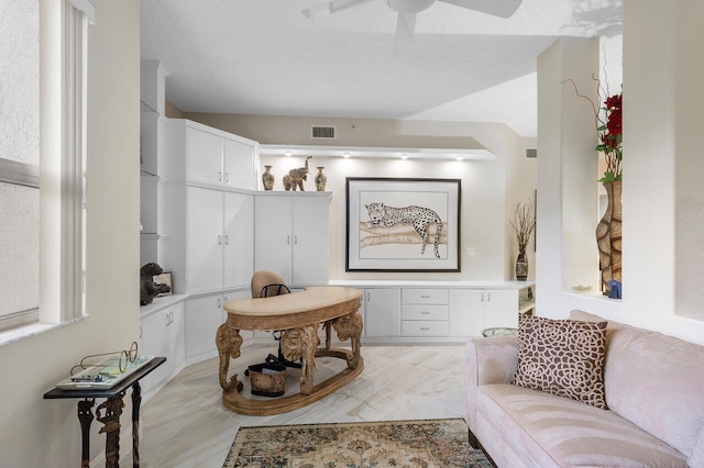 sitting room featuring a textured ceiling and ceiling fan