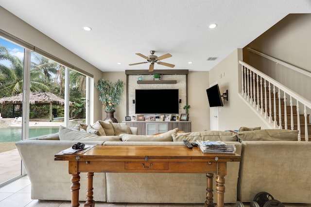 tiled living room featuring a textured ceiling and ceiling fan