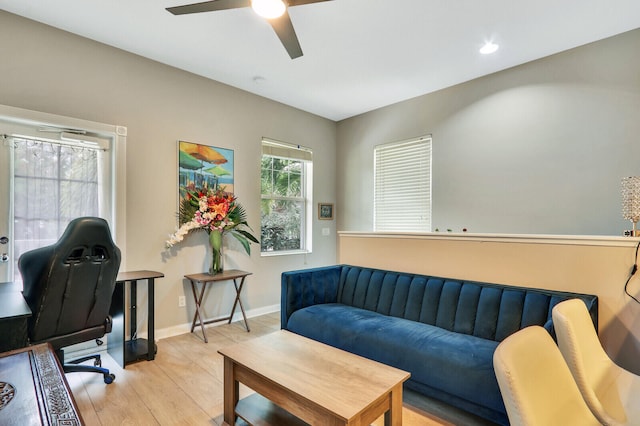 living room featuring light hardwood / wood-style flooring and ceiling fan