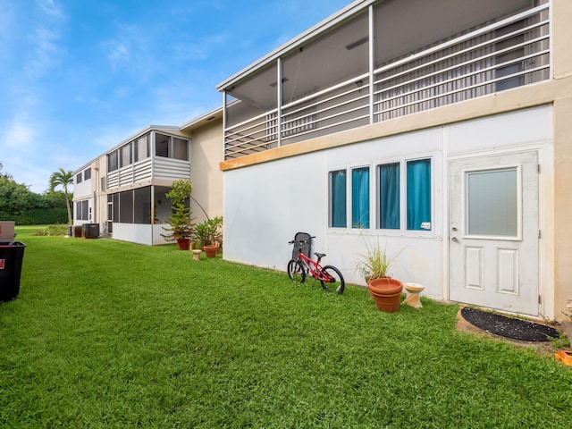 back of property with a lawn and central AC