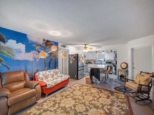 living room with a textured ceiling and ceiling fan