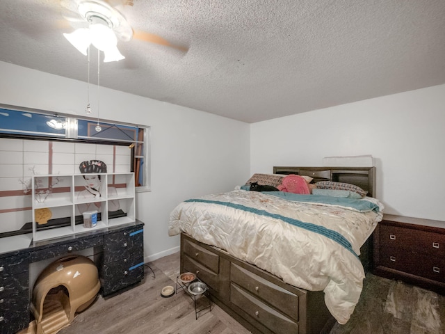 bedroom featuring a textured ceiling, wood-type flooring, and ceiling fan