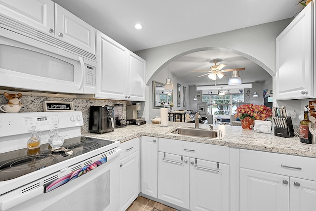 kitchen with white appliances, sink, ceiling fan, and white cabinets