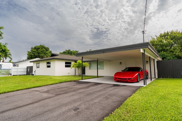 view of front of property with a carport and a front lawn