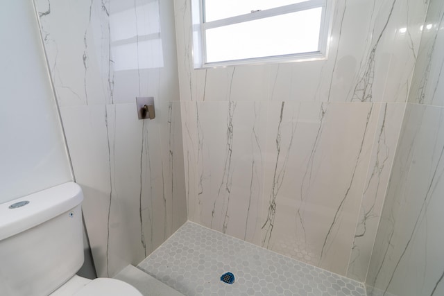 bathroom with toilet and a tile shower