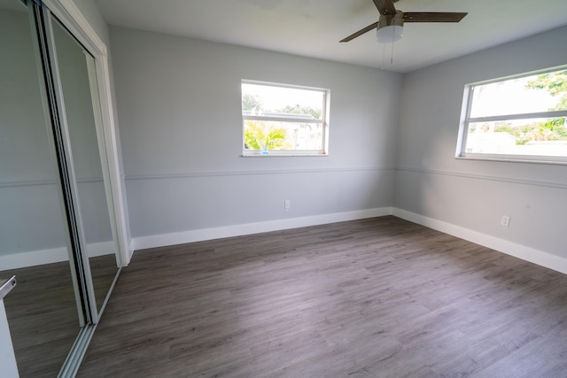 unfurnished bedroom featuring ceiling fan, a closet, and dark hardwood / wood-style flooring