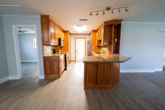 kitchen featuring decorative backsplash, wood-type flooring, crown molding, and stainless steel appliances