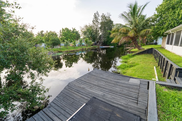 dock area featuring a water view and a lawn