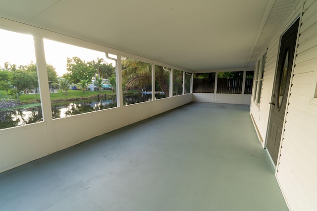 unfurnished sunroom featuring a water view