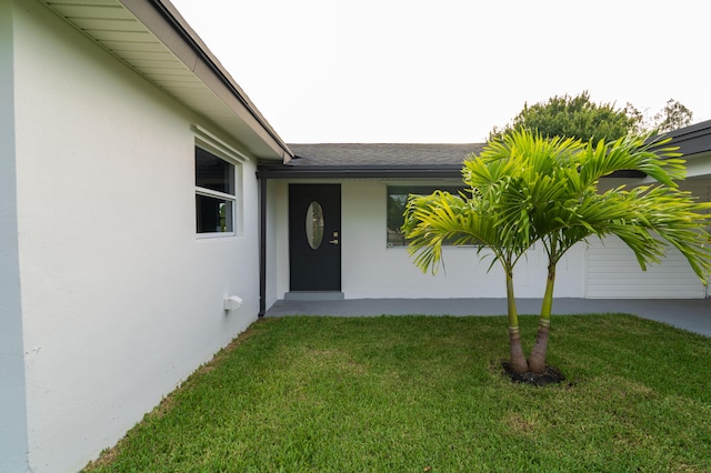 view of exterior entry featuring a yard