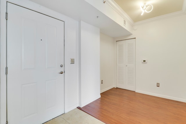 entryway with light hardwood / wood-style floors and ornamental molding