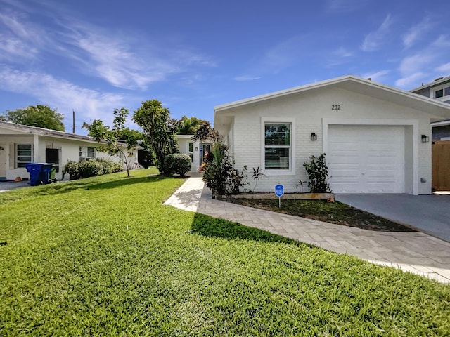 232 NW 25th St, Wilton Manors, FL 33311 - view of front of property with a front lawn, brick siding, a garage, and driveway