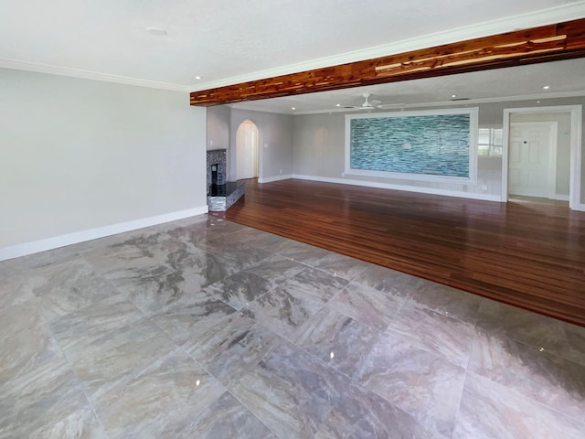 unfurnished living room with ceiling fan, hardwood / wood-style floors, a brick fireplace, and crown molding