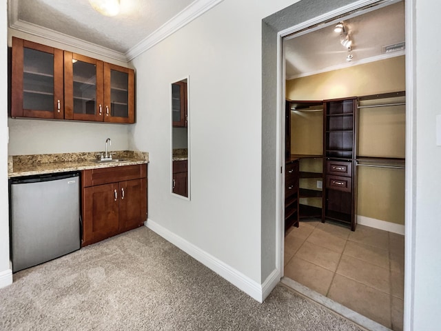 232 NW 25th St, Wilton Manors, FL 33311 - indoor wet bar featuring ornamental molding, baseboards, freestanding refrigerator, and light colored carpet
