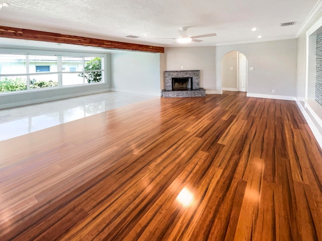 unfurnished living room with a textured ceiling, hardwood / wood-style flooring, ceiling fan, and a fireplace