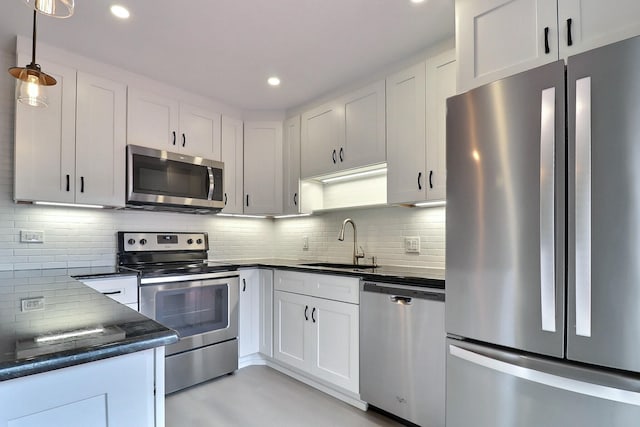 kitchen with pendant lighting, white cabinetry, sink, and appliances with stainless steel finishes