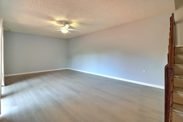 unfurnished room with a textured ceiling, ceiling fan, and dark hardwood / wood-style floors