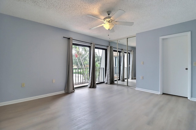 empty room with a textured ceiling, light hardwood / wood-style floors, and ceiling fan