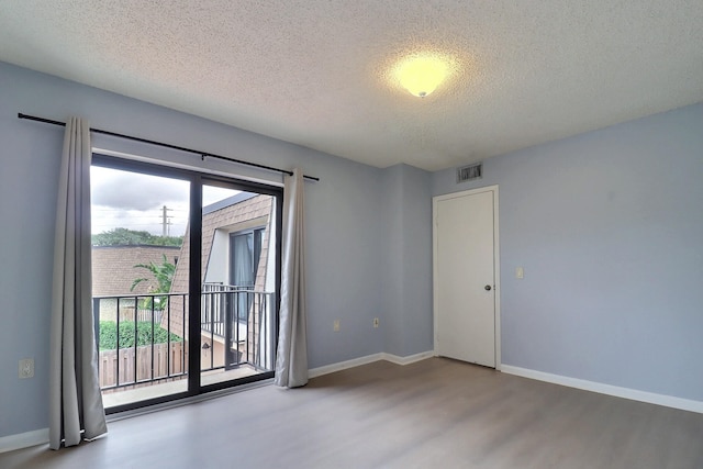 empty room featuring hardwood / wood-style floors and a textured ceiling