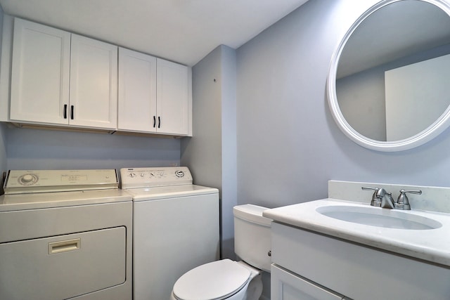 bathroom featuring vanity, toilet, and washing machine and clothes dryer