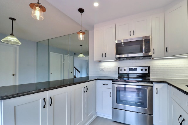 kitchen featuring backsplash, white cabinetry, hanging light fixtures, and stainless steel appliances