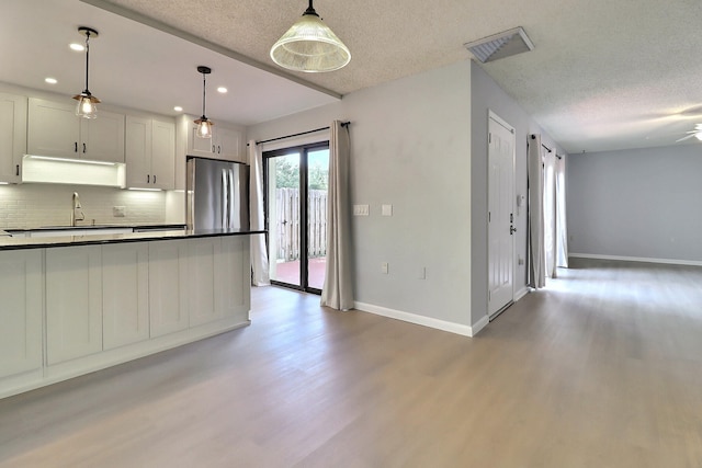 kitchen featuring hardwood / wood-style flooring, ceiling fan, decorative backsplash, decorative light fixtures, and white cabinetry