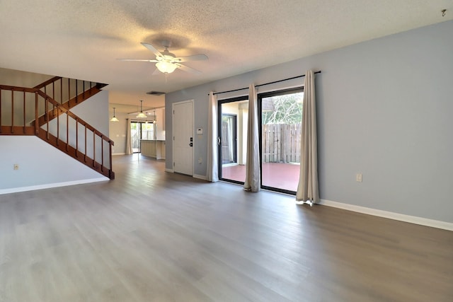 empty room featuring ceiling fan, hardwood / wood-style floors, and a textured ceiling