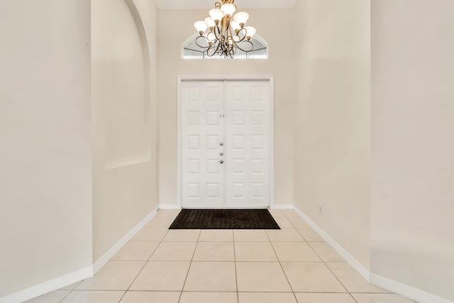 tiled entryway featuring an inviting chandelier