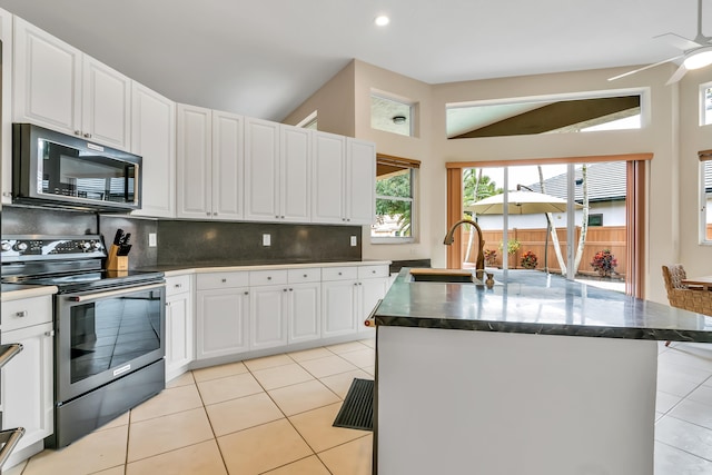 kitchen with white cabinetry, sink, electric stove, and an island with sink