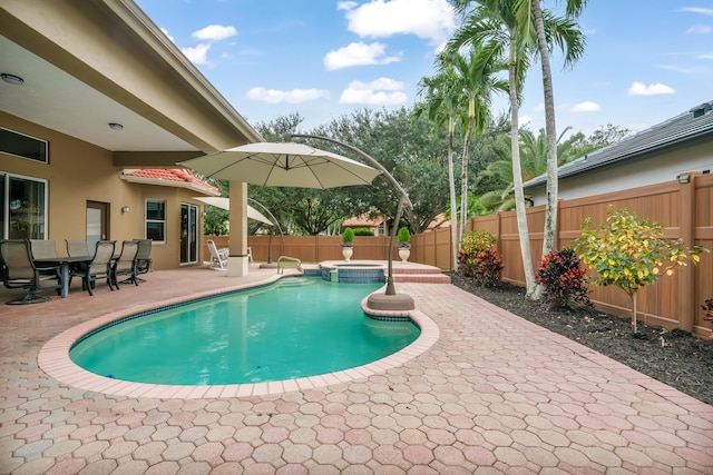 view of swimming pool featuring a patio area and an in ground hot tub