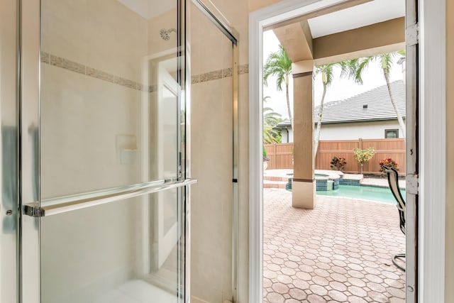 bathroom with a shower with door and a wealth of natural light