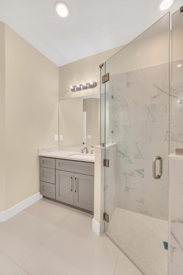 bathroom featuring a shower with shower door, vanity, and tile patterned flooring