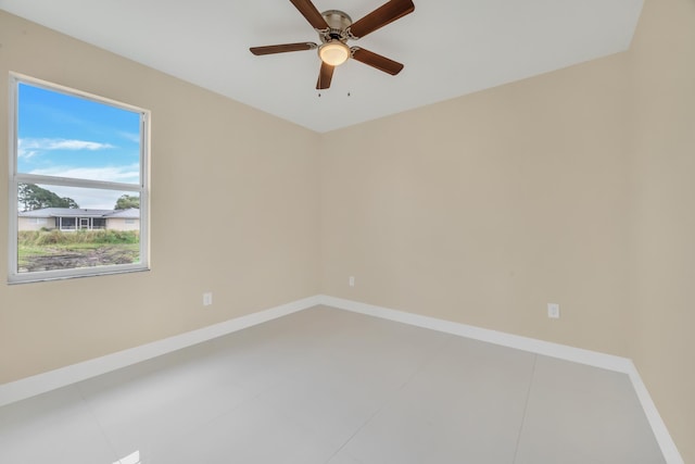 tiled spare room with ceiling fan