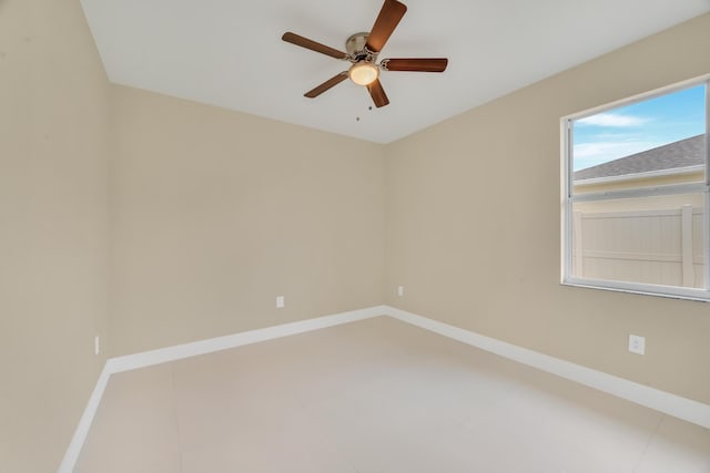 tiled spare room with ceiling fan