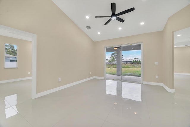 tiled empty room with ceiling fan, a wealth of natural light, and lofted ceiling