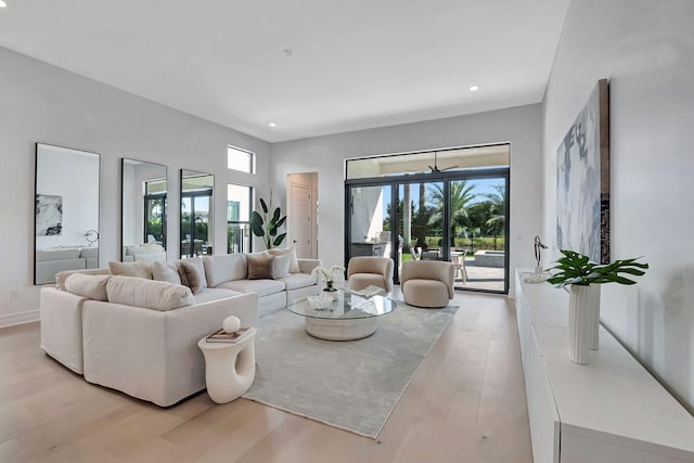 living room with light hardwood / wood-style flooring, a healthy amount of sunlight, and french doors