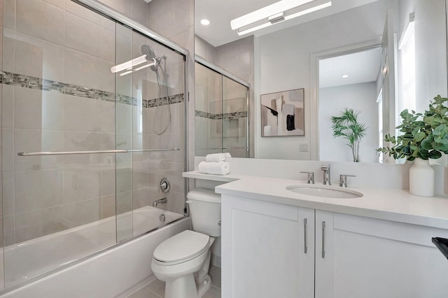 full bathroom featuring tile patterned floors, vanity, toilet, and bath / shower combo with glass door