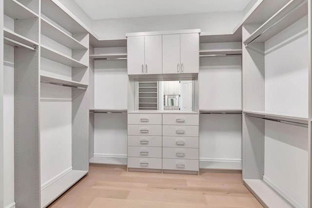 walk in closet with light hardwood / wood-style flooring