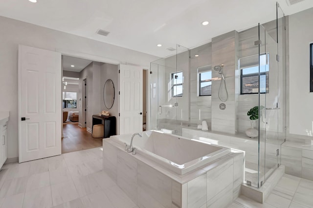 bathroom with plus walk in shower, vanity, and hardwood / wood-style flooring