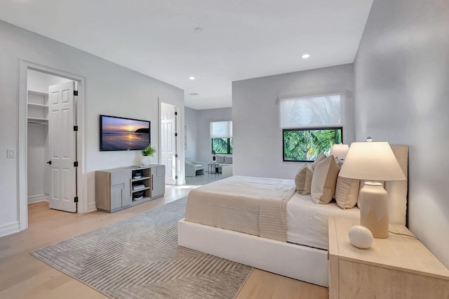 bedroom featuring light hardwood / wood-style floors, a spacious closet, and a closet