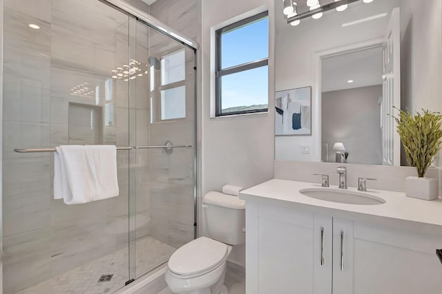 bathroom featuring vanity, toilet, and a shower with door