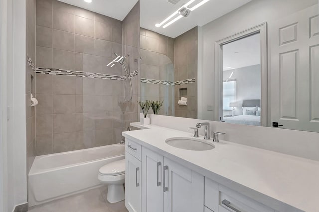 full bathroom featuring tile patterned flooring, vanity, toilet, and tiled shower / bath