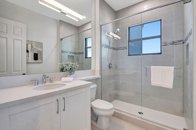 bathroom featuring vanity, an enclosed shower, and toilet