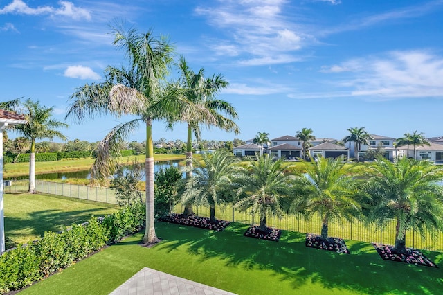 view of property's community featuring a lawn and a water view