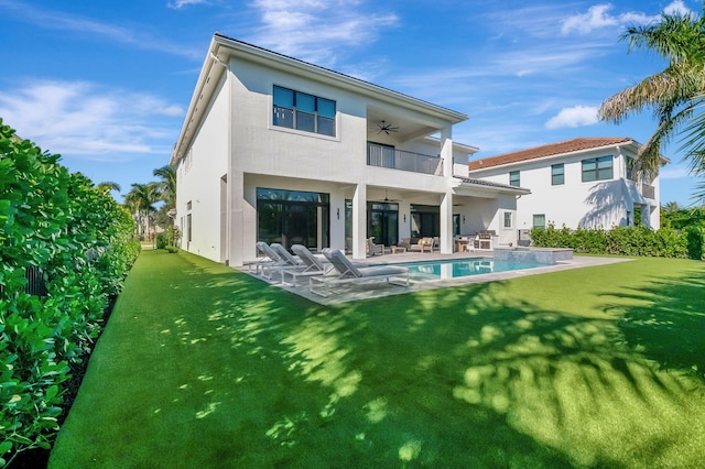 back of house with a lawn, ceiling fan, a balcony, and a patio