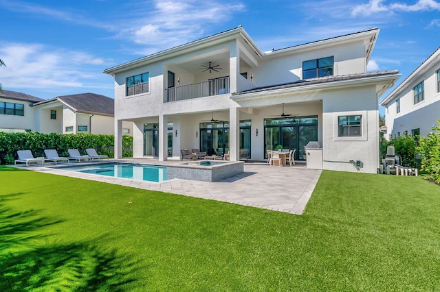 rear view of property with a patio, a balcony, ceiling fan, and a lawn