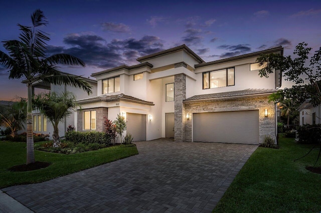 view of front of home with a garage and a yard