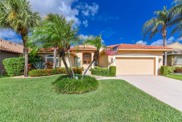 mediterranean / spanish house featuring a front yard and a garage