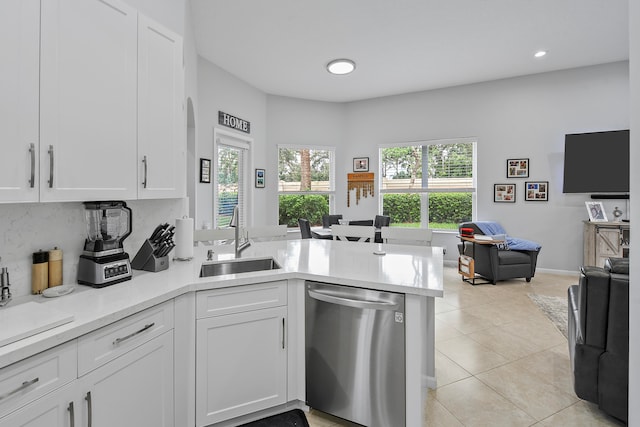 kitchen featuring white cabinets, dishwasher, sink, and a wealth of natural light