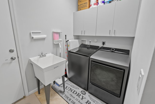 laundry area with washer and dryer, light tile patterned flooring, cabinets, and sink